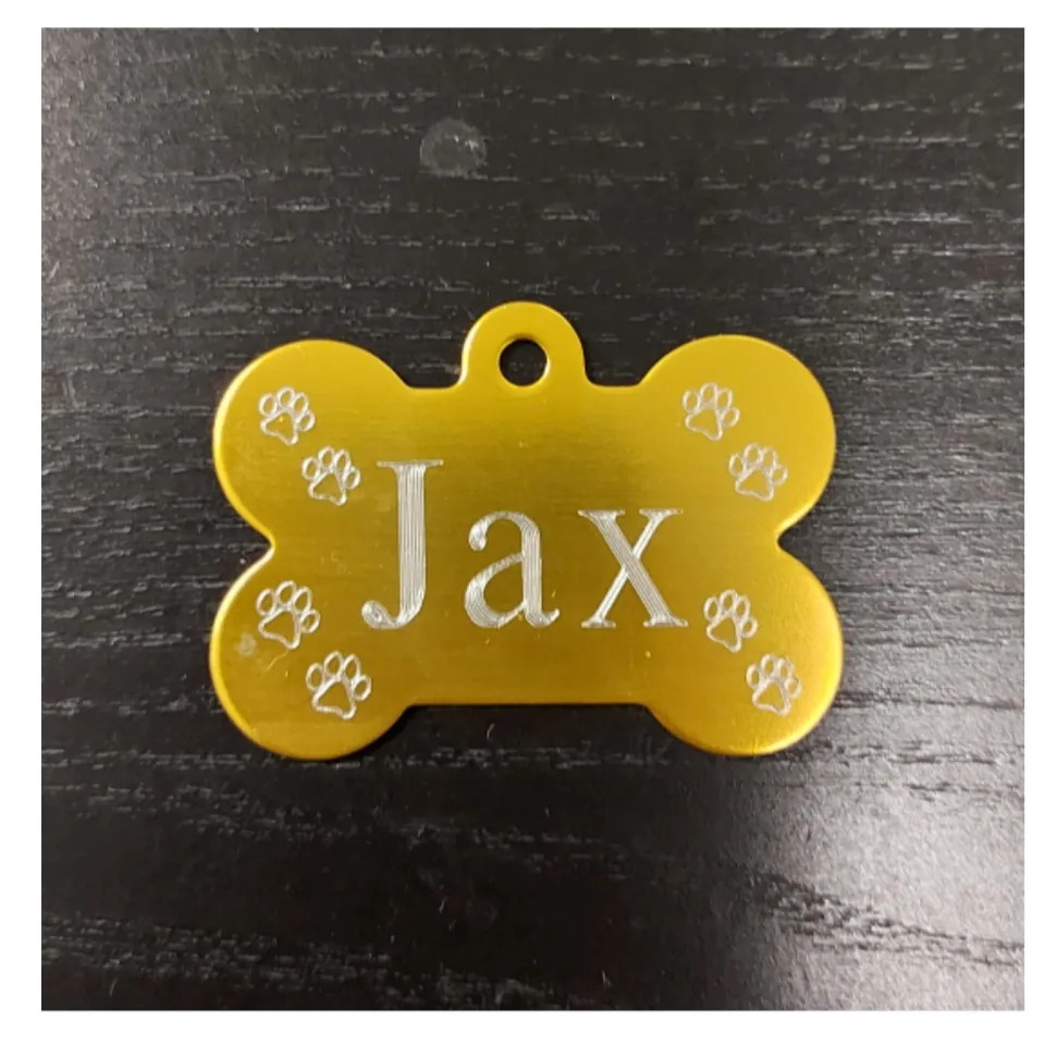 Gold bone-shaped pet ID tag engraved with the name Jax and paw prints