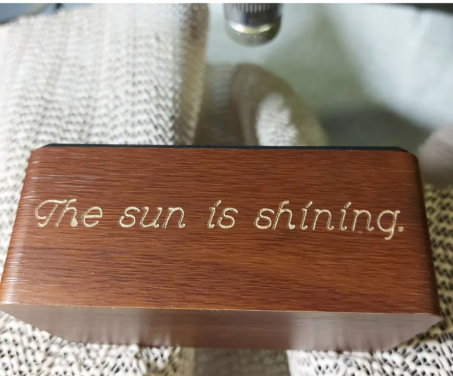 Dark wooden box engraved in script with the words The sun is shining